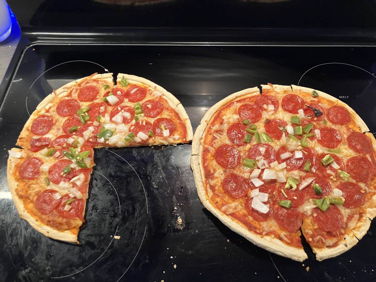 Two homemade pizzas fresh out of the oven